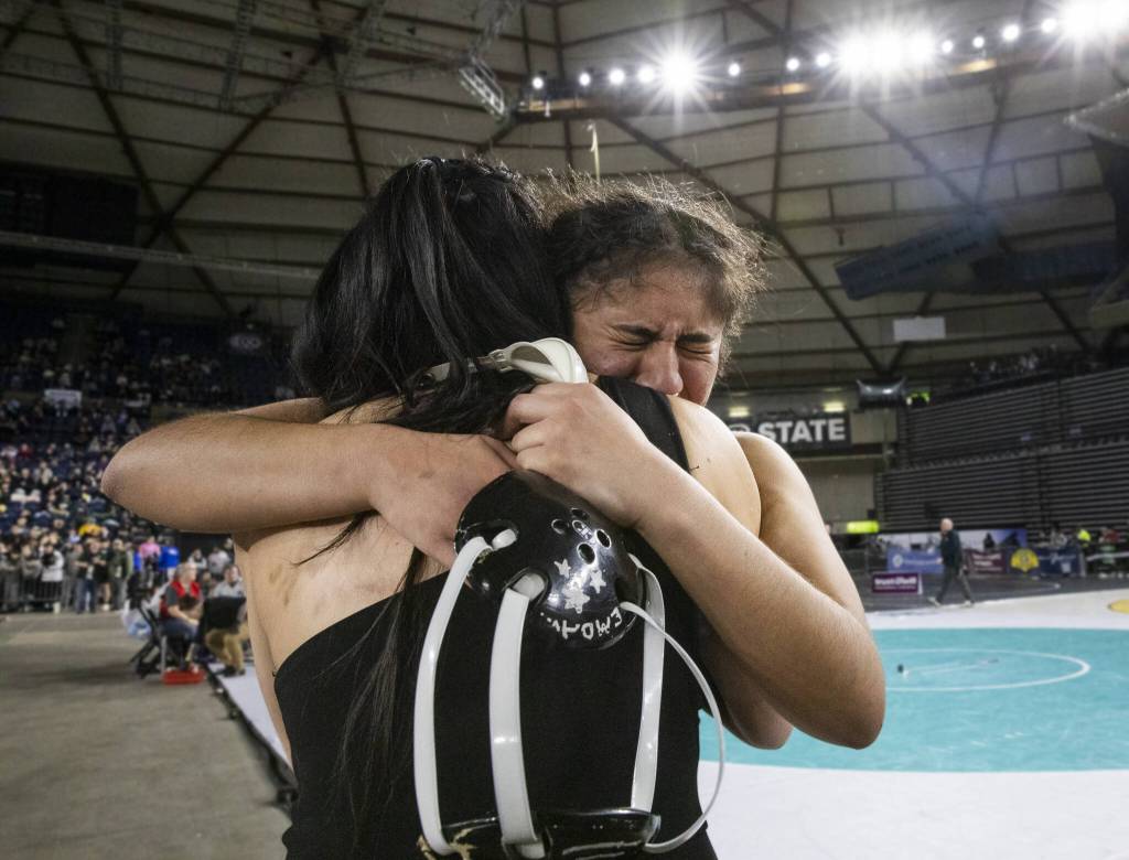 Jacksons Emily Ortiz Marque cries and hugs her coach after winning the at the 4A girls 170-pound championship title Mat Classic on Friday, Feb. 21, 2025 in Tacoma, Washington. (Olivia Vanni / The Herald)