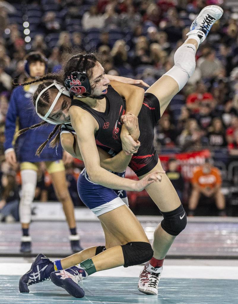 Glacier Peaks Cameron Erdmann flips her opponent in the air during the 4A girls 110-pound championship match at the Mat Classic on Friday, Feb. 21, 2025 in Tacoma, Washington. (Olivia Vanni / The Herald)