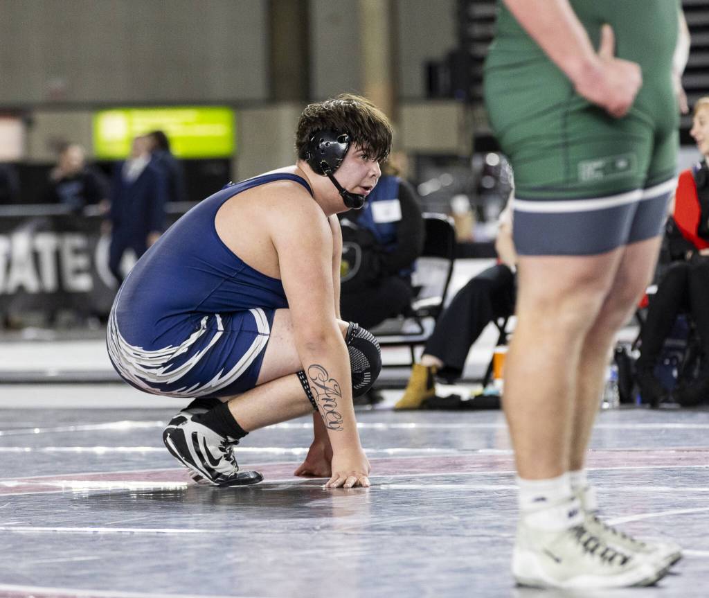 Glacier Peaks Connor Aney squats on the ground between overtimes during the 4A boys 285-pound championship match at the Mat Classic on Friday, Feb. 21, 2025 in Tacoma, Washington. (Olivia Vanni / The Herald)
