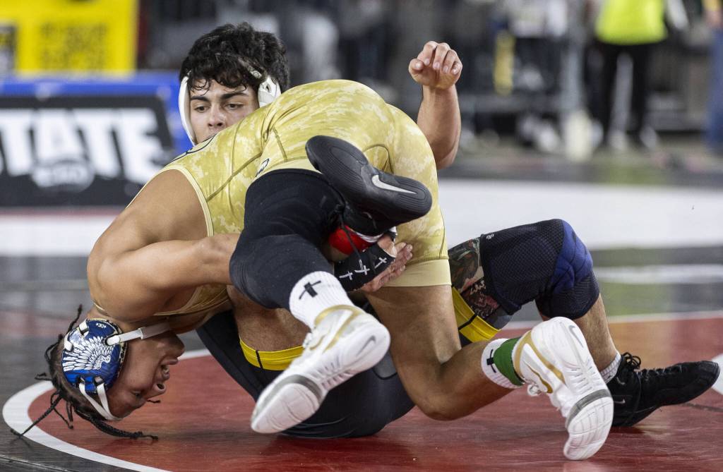 Arlingtons Tre Haines rolls onto his opponent during the 4A boys 165-pound championship match at the Mat Classic on Friday, Feb. 21, 2025 in Tacoma, Washington. (Olivia Vanni / The Herald)