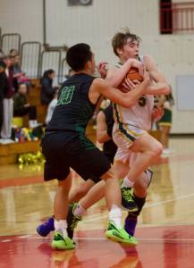 Marysville-Getchell senior Bubba Palacol (10) attempts to wrestle the ball from Shorecrest junior Brayden Fischer in Shorecrest's 46-44 win to qualify for a state tournament spot in Marysville, Washington on Feb. 22, 2025. (Joe Pohoryles / The Herald)