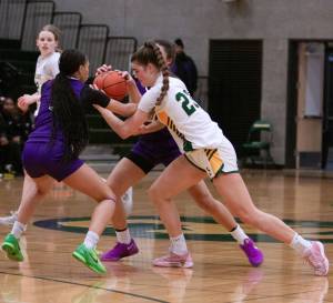 Shorecrests Cassie Chesnut has the ball stripped by Garfield defenders during a Feb. 25, 2025 state playoff game at Shorecrest High School. (Qasim Ali / The Herald)