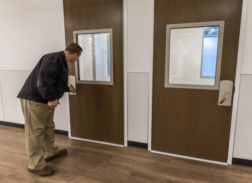 Chuck Steichen opens the door to one of the single occupant rooms on the second floor of the Lynnwood Crisis Care Center on Friday, Feb. 7, 2025 in Lynnwood, Washington. (Olivia Vanni / The Herald)
