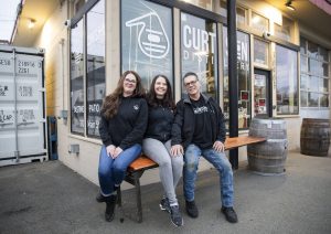 Curtson Distillery owners Robert Thompson, right, Malinda Curtis, center, and employee Sarah Trocano, left, at the distillery in Sultan. (Olivia Vanni / The Herald)
