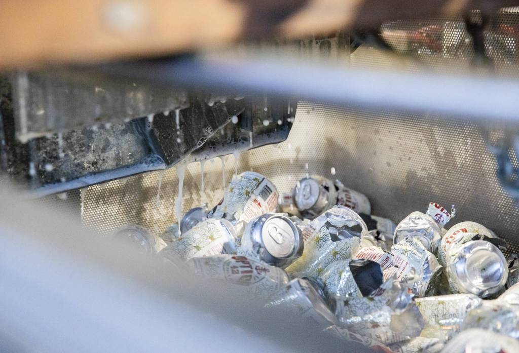 Beer drips down from the makeshift can crusher at Curtson Distillery. (Olivia Vanni / The Herald)