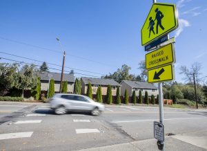 A car drives along Lockwood Road in front of Lockwood Elementary School pas the new flashing crosswalk on Monday, Sept. 30, 2024 in Bothell, Washington. (Olivia Vanni / The Herald)