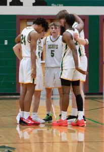 The Shorecrest boys basketball starters huddle during a Feb. 28, 2025 3A state playoff game against Liberty at Jackson High School. (Qasim Ali / The Herald)