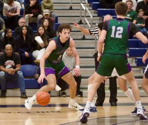 Edmonds-Woodway senior Cam Hiatt dribbles around a defender as junior William Alseth (12) sets a screen against a Bellevue defender during the Warriors' 66-56 overtime win in Bellevue, Washington on March 1, 2025. Hiatt scored 37 points to propel the fifth-seeded Warriors to the Boys 3A Basketball State quarterfinals. (Joe Pohoryles / The Herald)