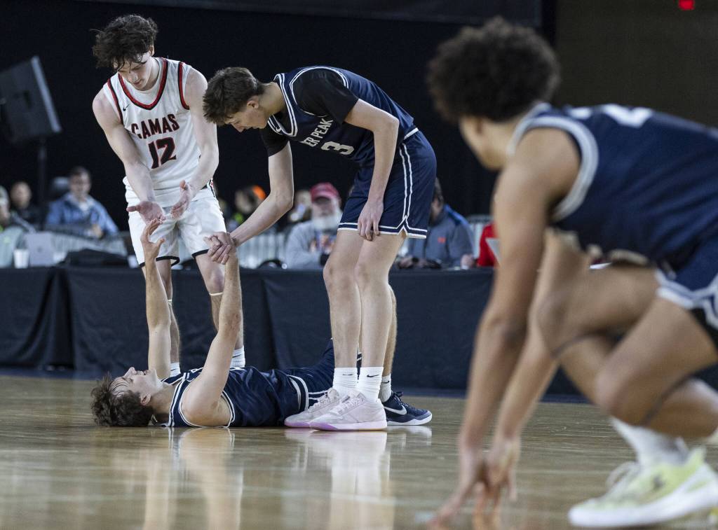 Glacier Peaks Jo Lee is helped up by his teammate Jack Taylor and Camas Jace VanVoorhis after the final buzzer sending the game into overtime during the 4A boys quarterfinal game against Camas on Thursday, March 6, 2025 in Tacoma, Washington. (Olivia Vanni / The Herald)