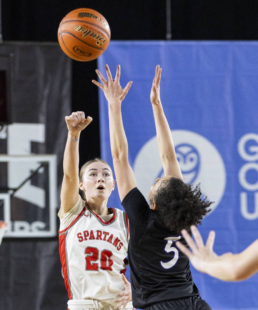 Stanwoods Presley Harris passes the ball over the outstretched arms of a Garfield player during the 3A girls quarterfinal game against Garfield on Thursday, March 6, 2025 in Tacoma, Washington. (Olivia Vanni / The Herald)