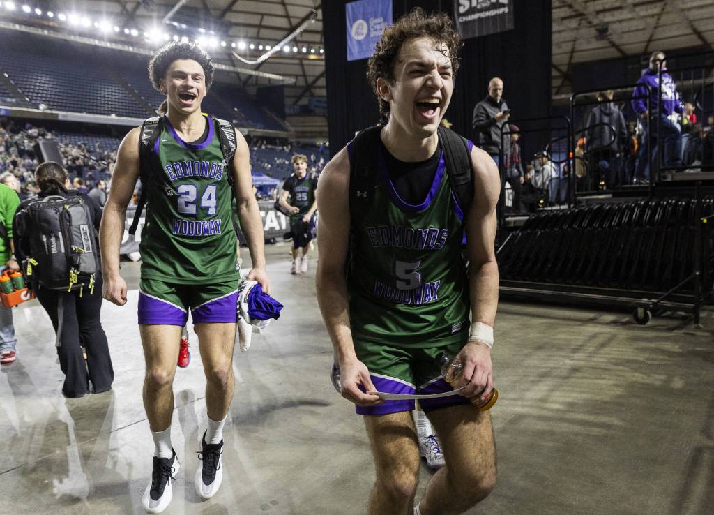 Edmonds-Woodways Cameron Hiatt runs with the Edmonds-Woodway label to place it on the championship game on the bracket poster on Friday, March 7, 2025 in Tacoma, Washington. (Olivia Vanni / The Herald)
