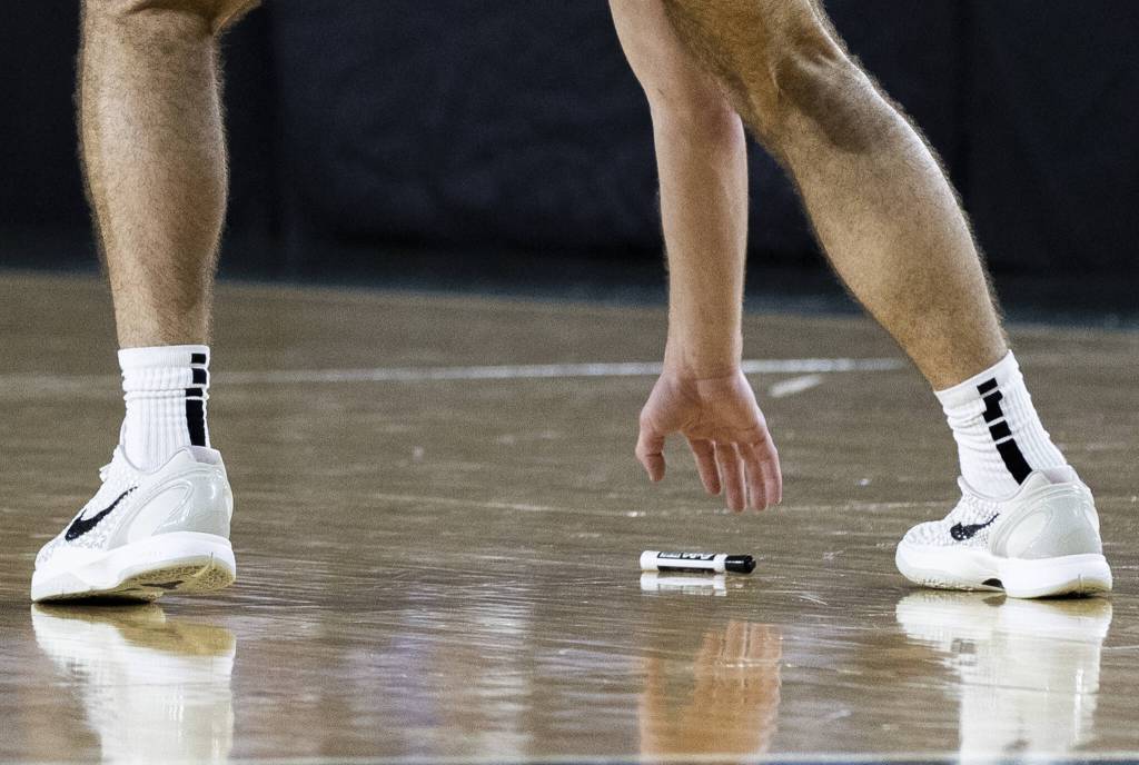 Edmonds-Woodways Cam Hiatt picks up an Expo marker from the court after Edmonds-Woodway head coach Tyler Geving threw his whiteboard on the ground during the 3A boys championship game against Rainier Beach on Saturday, March 8, 2025 in Tacoma, Washington. (Olivia Vanni / The Herald)