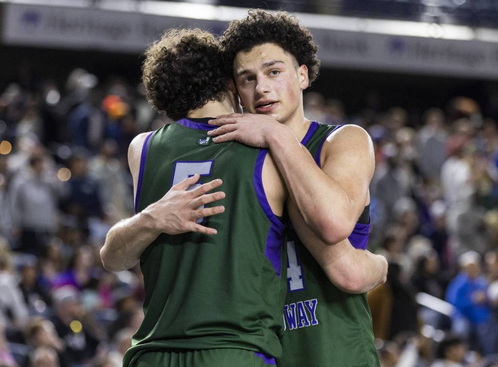 Edmonds-Woodways Julian Gray hugs his teammate Cam Hiatt after they both come out of the 3A boys championship game in the final minute on Saturday, March 8, 2025 in Tacoma, Washington. (Olivia Vanni / The Herald)