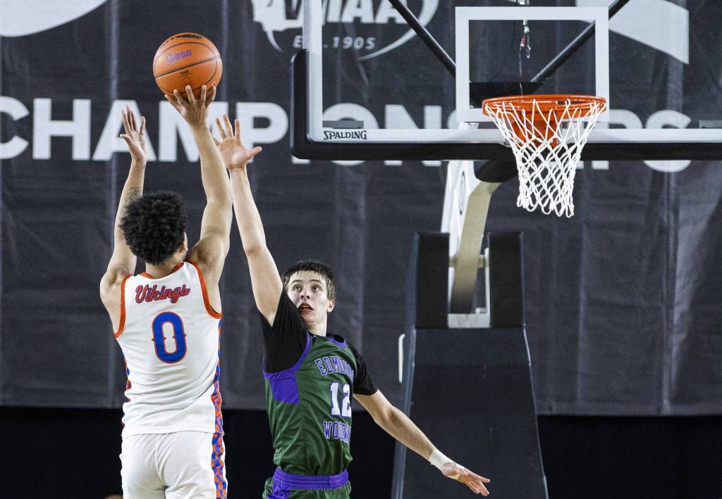 Edmonds-Woodways William Alseth reaches his area up to try and block a shot by Rainier Beachs Kaden Powers during the 3A boys championship game on Saturday, March 8, 2025 in Tacoma, Washington. (Olivia Vanni / The Herald)
