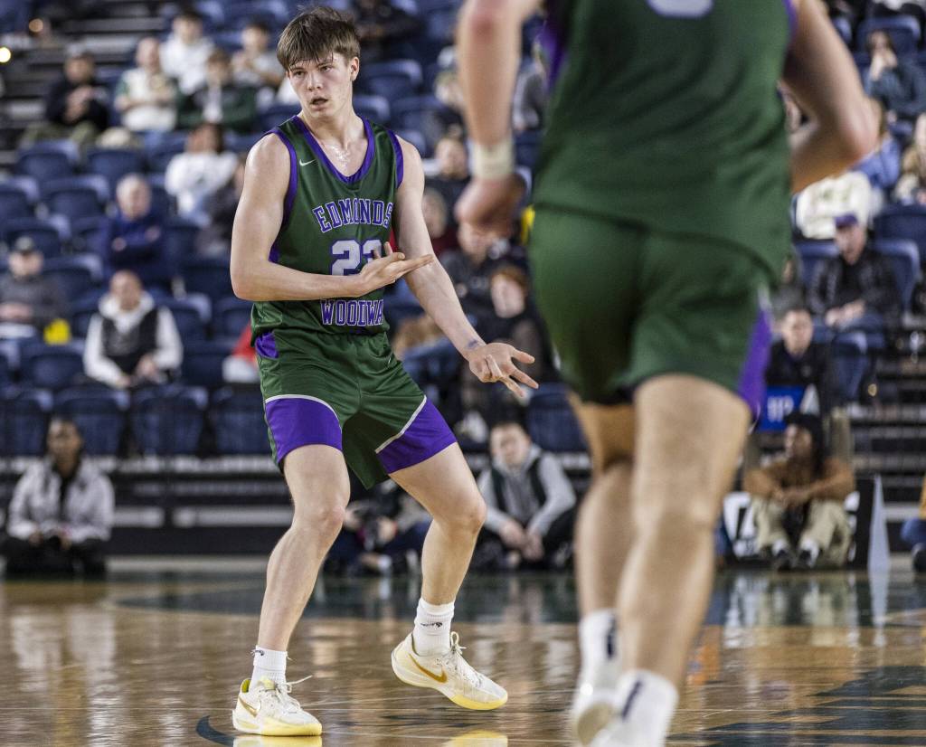 Edmonds-Woodways DJ Karl points toward his arm after making a 3-point shot during the 3A boys championship game against Rainier Beach on Saturday, March 8, 2025 in Tacoma, Washington. (Olivia Vanni / The Herald)