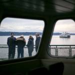 A group of travelers aboard the MV Suquamish watch from the sun deck as MV Tokitae passes starboard side on Thursday, Sept. 7, 2023, in the waters near Clinton, Washington. (Ryan Berry / The Herald)