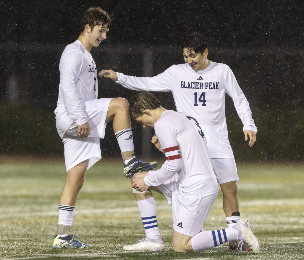 Glacier Peaks Federico Zamolo pretends to shine the shoes of his teammate Tyler Larsen to celebrate Larsens goal during the game against Snohomish on Wednesday, March 12, 2025 in Snohomish, Washington. (Olivia Vanni / The Herald)