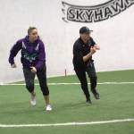 Wolfpack special teams coordinator Melissa Strothers (left) defensive coordinator Cole Stephens (right) participated during a drill at the Arena Football One teams practice at Snohomish Sports Dome on Thursday, March 13, 2025. (Aaron Coe / The Herald)