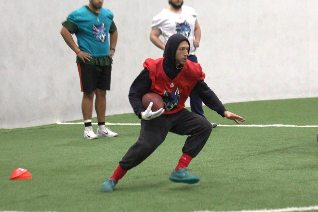 Washington Wolfpack quarterback Adam Kruse runs with the ball during the Arena Football One teams practice at Snohomish Sports Dome on Thursday, March 13, 2025. (Aaron Coe / The Herald)