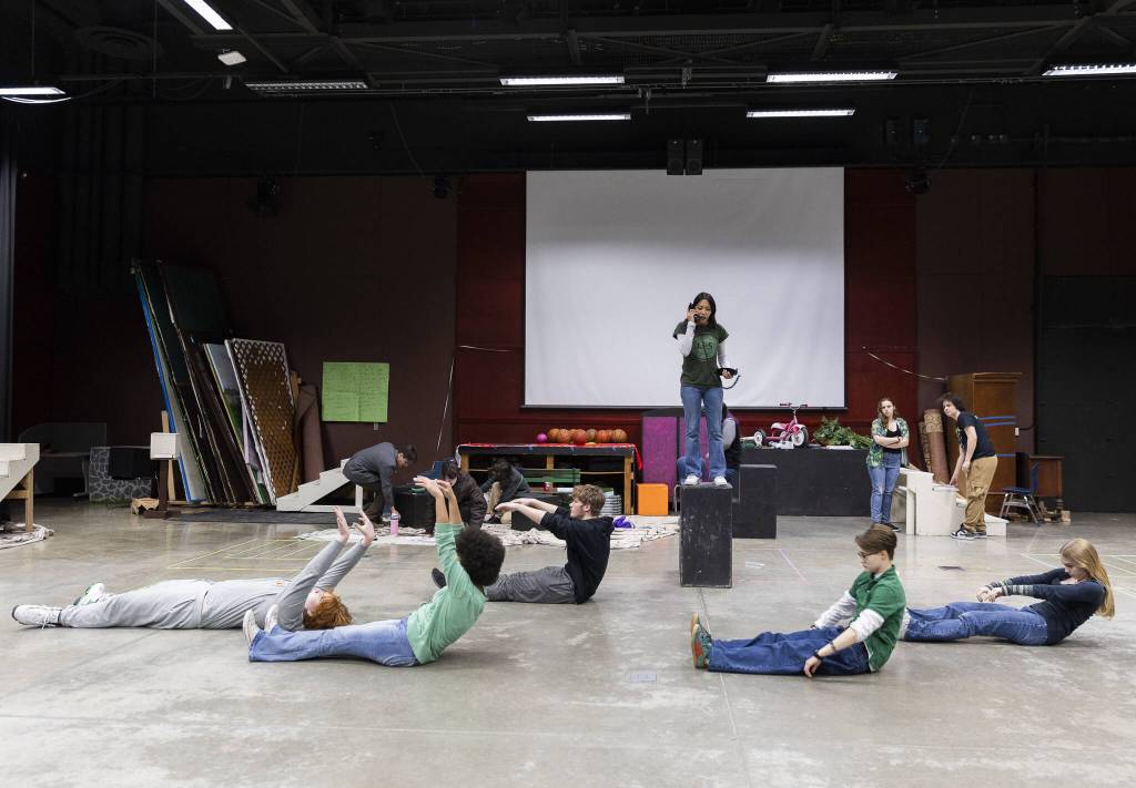 Orpheus, played by Seda San Nicolas, talks on a phone while in character during a full run-through at rehearsal on Monday, March 17, 2025, at Meadowdale High School in Lynnwood, Washington.. (Olivia Vanni / The Herald)