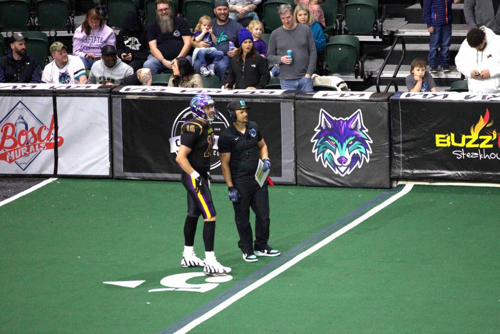 Washington coach J.R. Wells goes over the play call with starting quarterback Joe Hess (16) during the Washington Wolfpacks 63-33 loss at Angel of the Winds Arena on March 16, 2025. (Aaron Coe / The Herald)