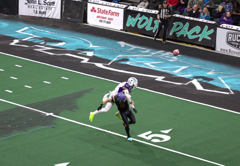Southwest Kansas defensive back Michael Lawson (4) breaks up a pass intended for Washington receiver Josh Meier (0) in the Wolfpacks 63-33 loss at Angel of the Winds Arena on March 16, 2025. (Aaron Coe / The Herald)