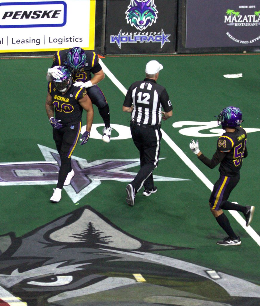 Linebacker Johnny Navarro (42) jumps on Deshon Williams (49) back after a fourth down stop in the Washington Wolfpacks 63-33 loss at Angel of the Winds Arena on March 16, 2025. (Aaron Coe / The Herald)