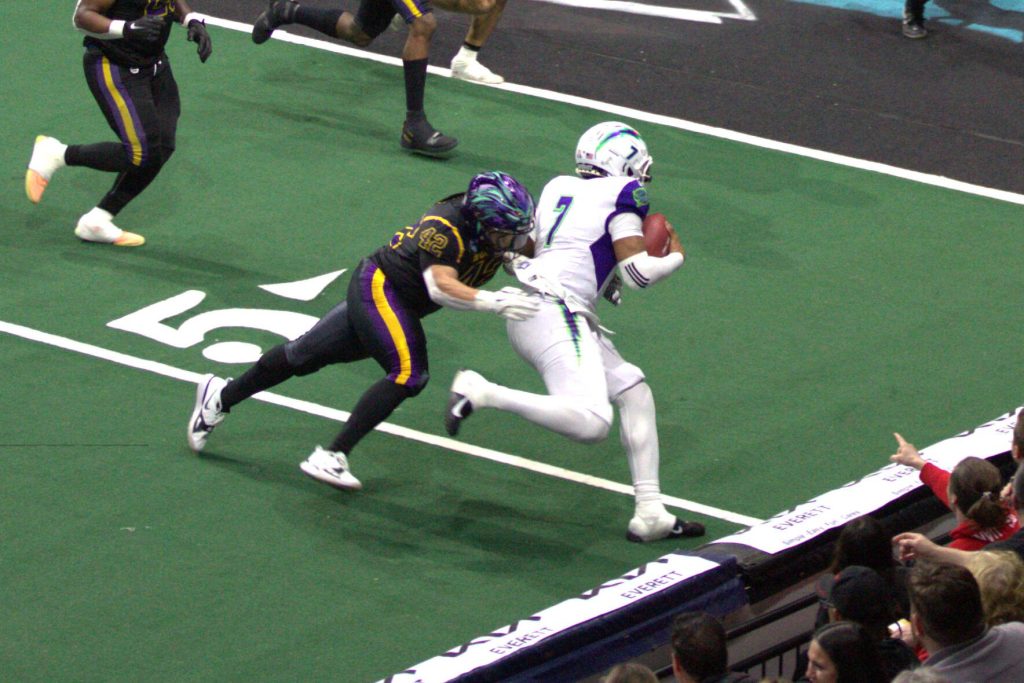 Washington linebacker Johnny Navarro (42) makes a tackle in the Wolfpacks 63-33 loss at Angel of the Winds Arena on March 16, 2025. (Aaron Coe / The Herald)