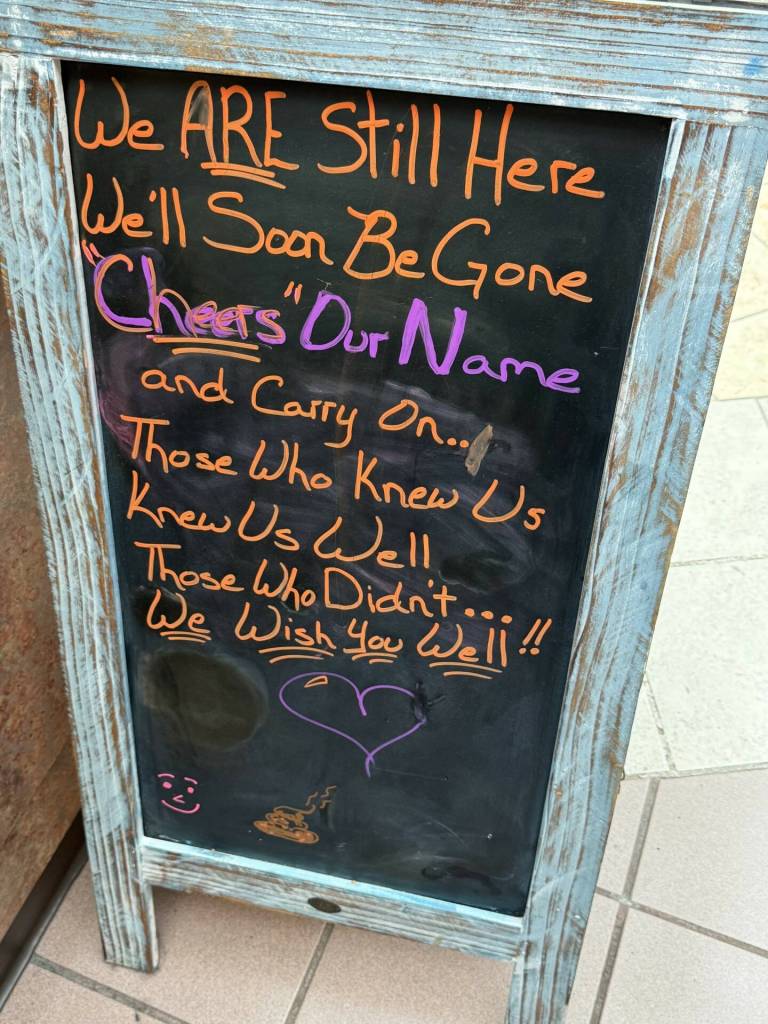 Mall kiosk owner Maureen McMahill, who runs an espresso stand, erected her own farewell sign by her business on Thursday, March 21, 2025, in Everett, Washington. The chalkboard, reads in part, We Are Still Here. Well Soon Be Gone, Cheers Our Name and Carry On. (Randy Diamond / The Herald)