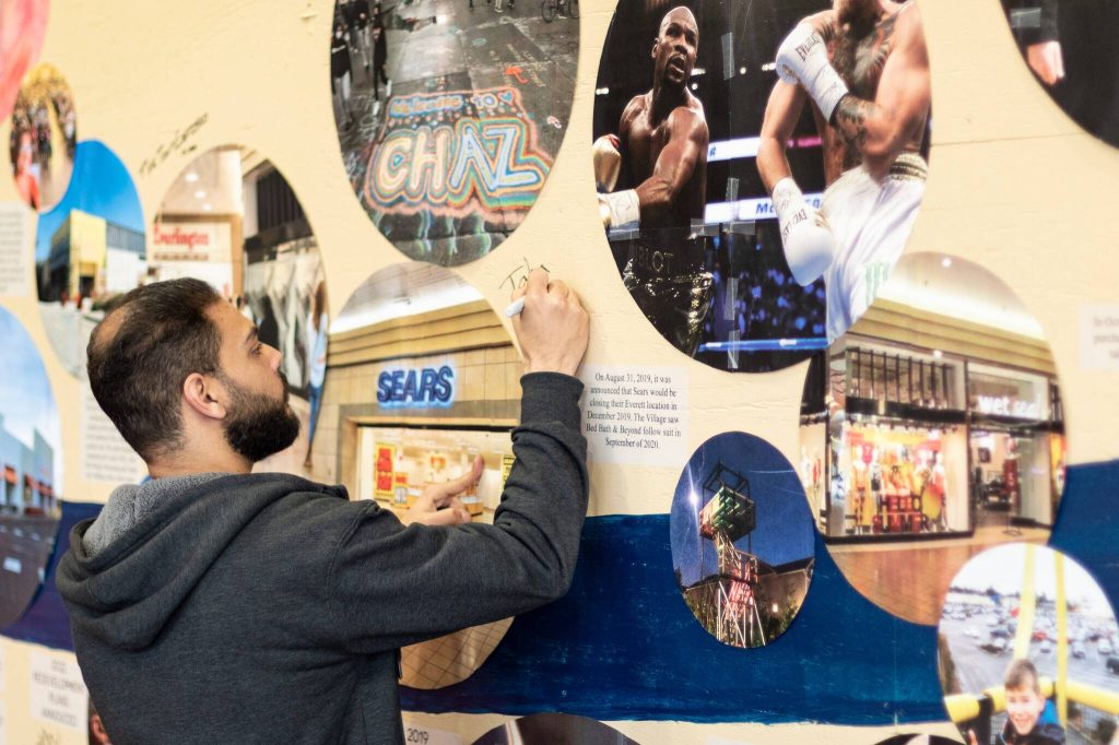 Photos by Aaron Kennedy / The Herald
Employees and patrons of the Everett Mall sign a timeline mural that traces the history of the 51-year-old indoor mall that was once considered the premier place to go shopping in the city, Thursday in Everett.