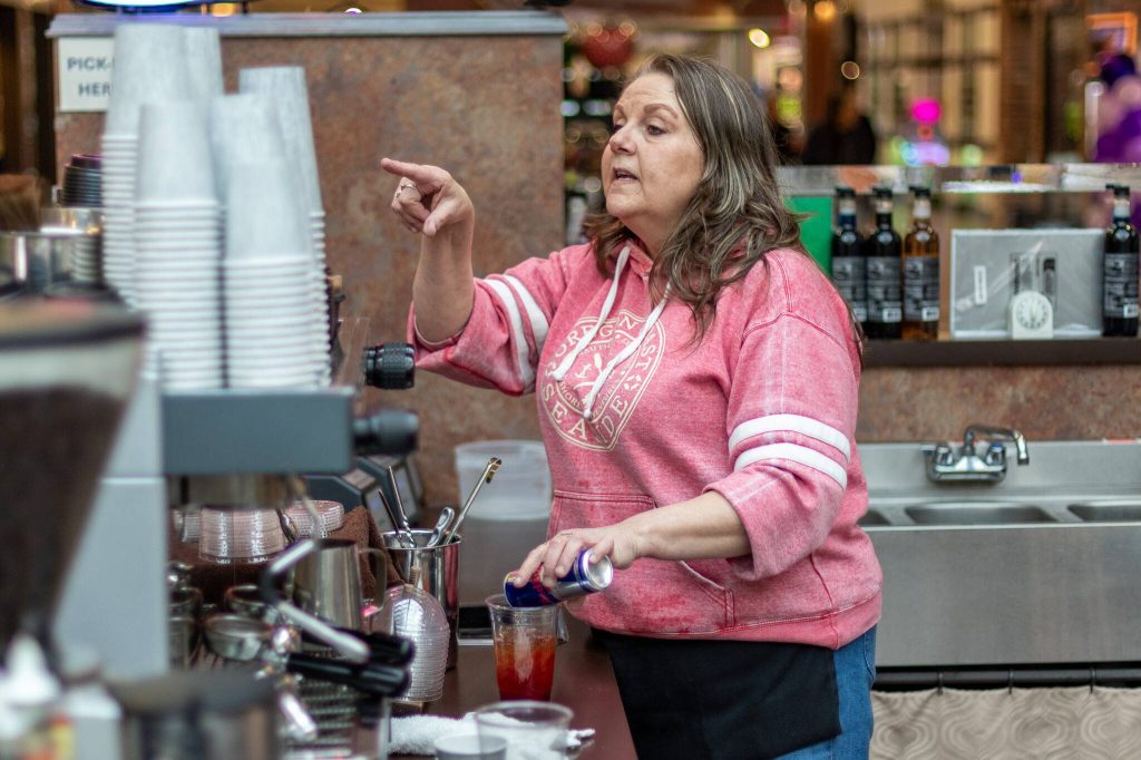 Mall kiosk owner Maureen McMahill takes drink orders Thursday in the Everett Mall.
