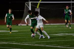 Shorewood senior Matthew Bereket fends off Edmonds-Woodway senior Joey Dornay during the first half of Shorewood's 2-1 overtime win in Edmonds, Washington on March 18, 2025. (Joe Pohoryles / The Herald)