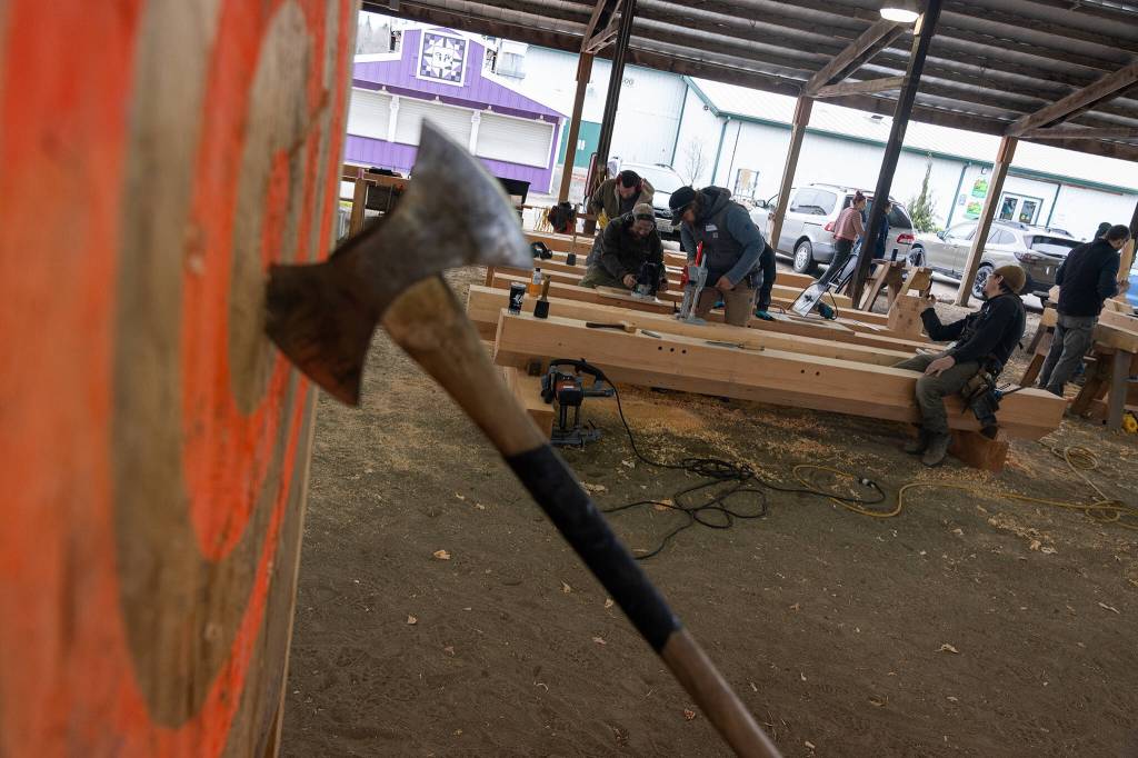 Volunteers with the Timber Framers Guild construct a community gathering space on Wednesday, March 19 in Monroe, Washington. (Will Geschke / The Herald)