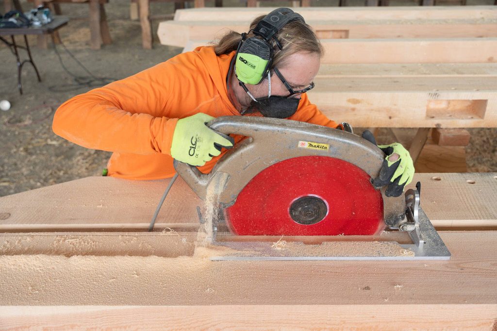 Nathan Gruenwuld uses a saw on Wednesday in Monroe.