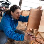 Elaina Jorgensen measures a tenon while volunteering with the Timber Framers Guild on Wednesday, March 19 in Monroe, Washington. (Will Geschke / The Herald)