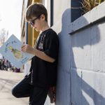 Oliver Popa, 7, poses with his book, Drippey Plants a Garden, on Tuesday, March 25, 2025 in Edmonds, Washington. (Olivia Vanni / The Herald)