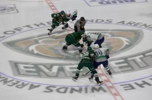 The Everett Silvertips and Seattle Thunderbirds meet at center ice for a faceoff during Game 1 of the WHL Playoffs First Round at Angel of the Winds Arena in Everett, Washington on March 28, 2025. (Joe Pohoryles / The Herald)