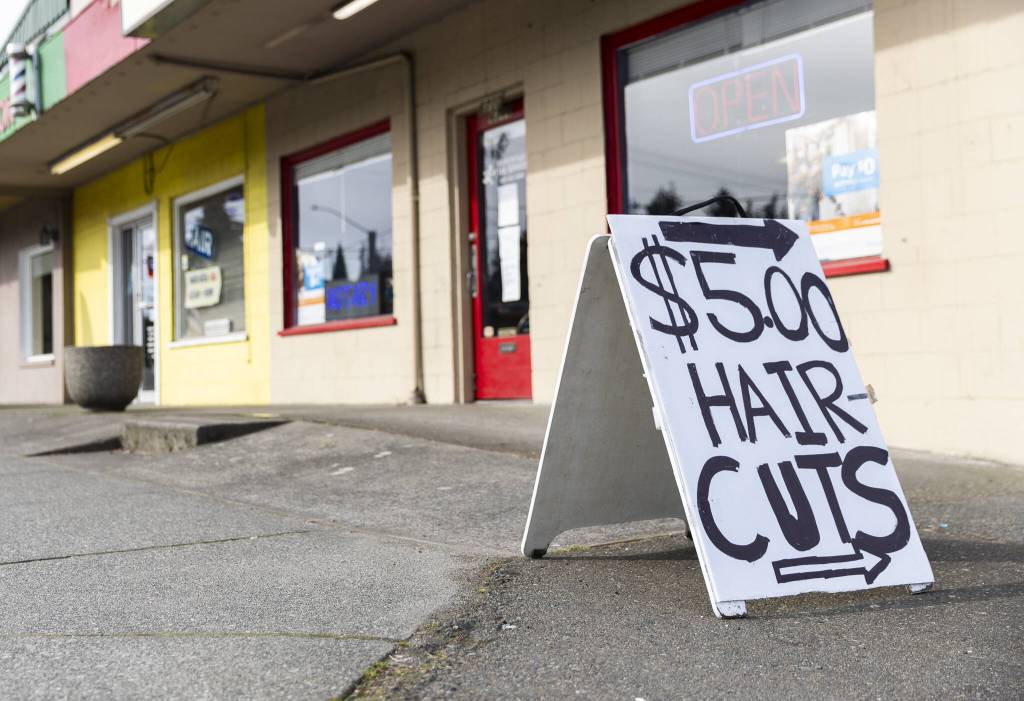 A $5 Haircuts sign sits on display along Evergreen Way in Everett. (Olivia Vanni / The Herald)