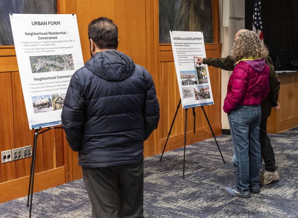 People look over information board on the Everett 2044 Comprehensive Plan update at the Everett Planning Department open house at Everett Station on Wednesday, Feb. 26, 2025 in Everett, Washington. (Olivia Vanni / The Herald)