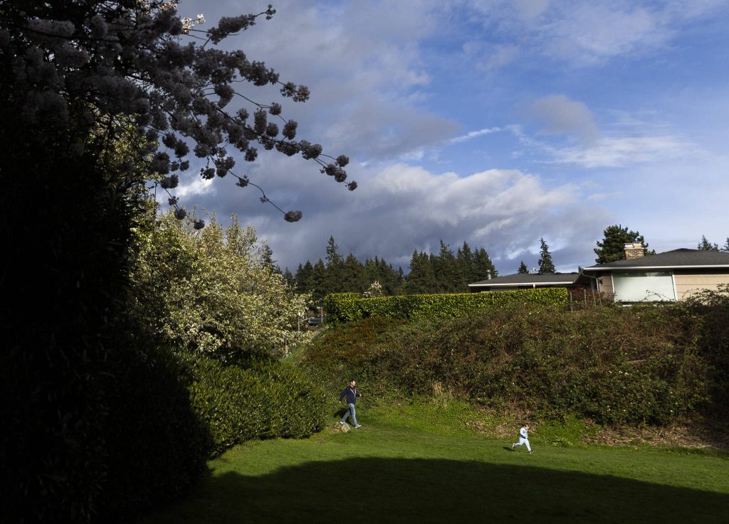 A child runs ahead of their parent into Hummingbird Hill Park on Monday, March 31, 2025, in Edmonds, Washington. (Olivia Vanni / The Herald)