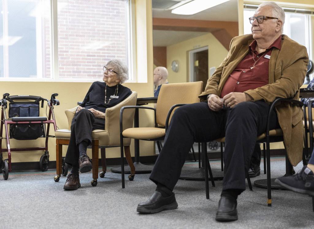 Mary Ann Karber, left, and Dave Anderson, right, sit in their designated seats before the start of Wheel of Fortune at Washington Oakes in Everett. (Olivia Vanni / The Herald)