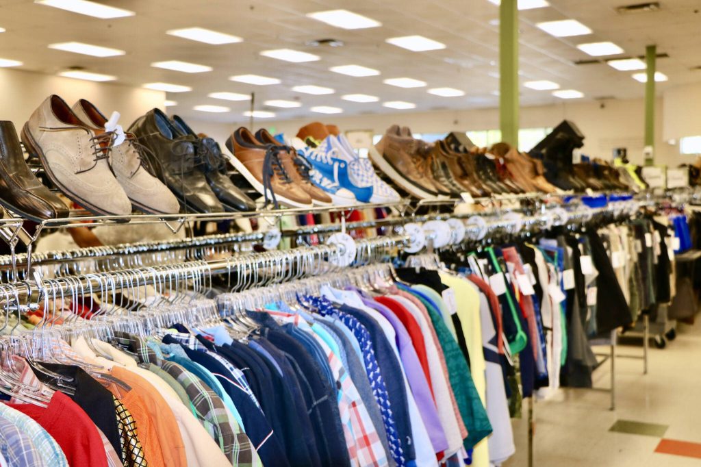 Clothes and shoes sit on a rack at Bellas Voice Thrift Store in Lynnwood, where employees have seen an uptick in retail theft, often calling the police three to five times a month. (Aspen Anderson / The Herald)