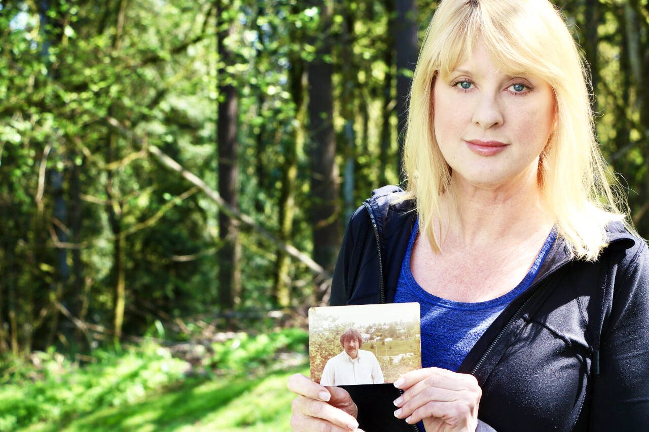 Wendy Banchero holds a photo of her late uncle, David DeDesrochers, outside her home in Woodinville. (Aspen Anderson / The Herald)