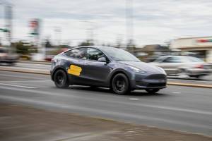 A Tesla drives along 41st Street on Wednesday, March 26, 2025 in Everett, Washington. (Olivia Vanni / The Herald)