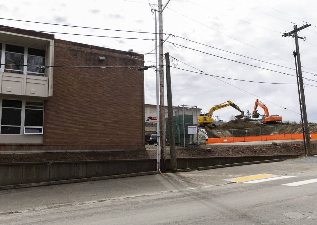 Two excavators dig behind Jackson Elementary School on Tuesday, April 1, 2025 in Everett, Washington. (Olivia Vanni / The Herald)