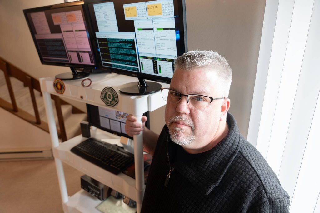 Daron Johnson, who runs Snohomish County Scanner, stands next to his scanner setup on Tuesday, April 1 in Everett, Washington. (Will Geschke / The Herald)