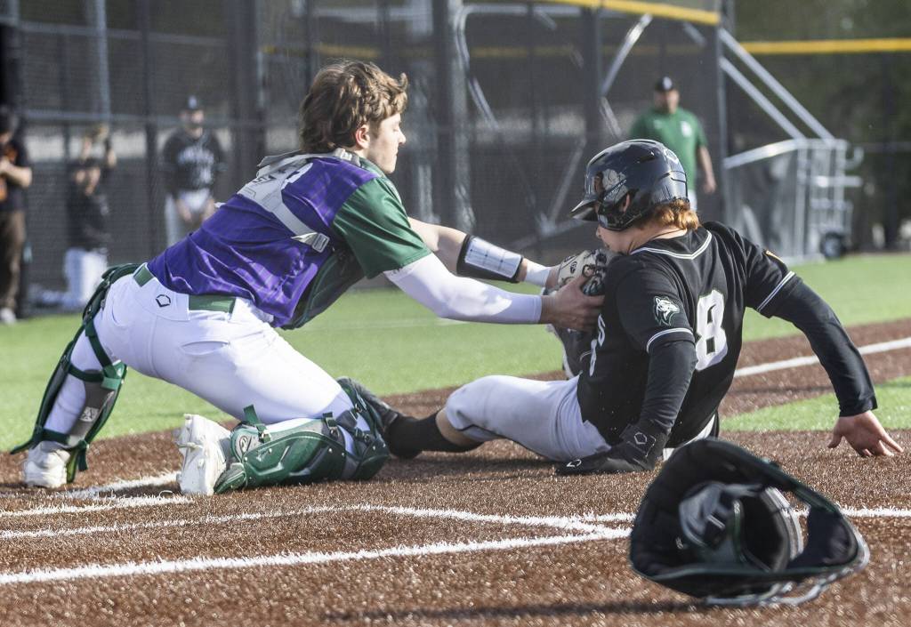 Edmonds-Woodways Trevelyan Podawiltz tags Jacksons Ashton Bergman as he slides into home for an out during the game on Wednesday, April 2, 2025 in Edmonds, Washington. (Olivia Vanni / The Herald)