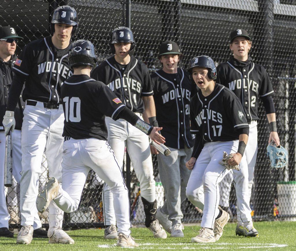Jackson players celebrate teammate MJ Holcomb scoring during the game against Edmonds-Woodway on Wednesday, April 2, 2025 in Edmonds, Washington. (Olivia Vanni / The Herald)