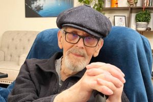 Bill France poses in one of his custom flat caps after asking his wife, Sarah France, to snap a photo.