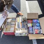 Bryson Fico sorts through book donations on Saturday, April 5, 2025, in Marysville, Washington. (Olivia Vanni / The Herald)
